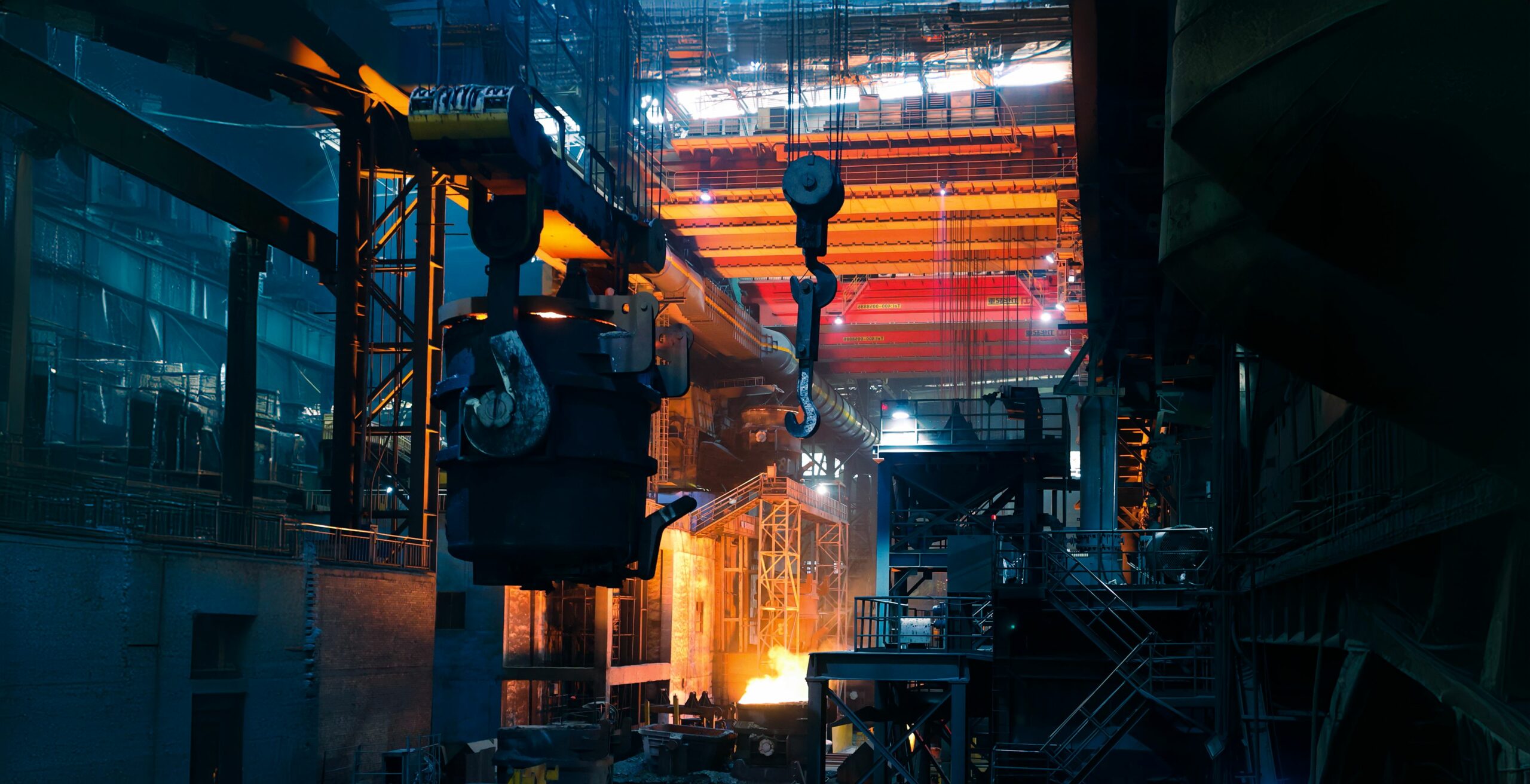 Interior de una acería con grúas y metal incandescente